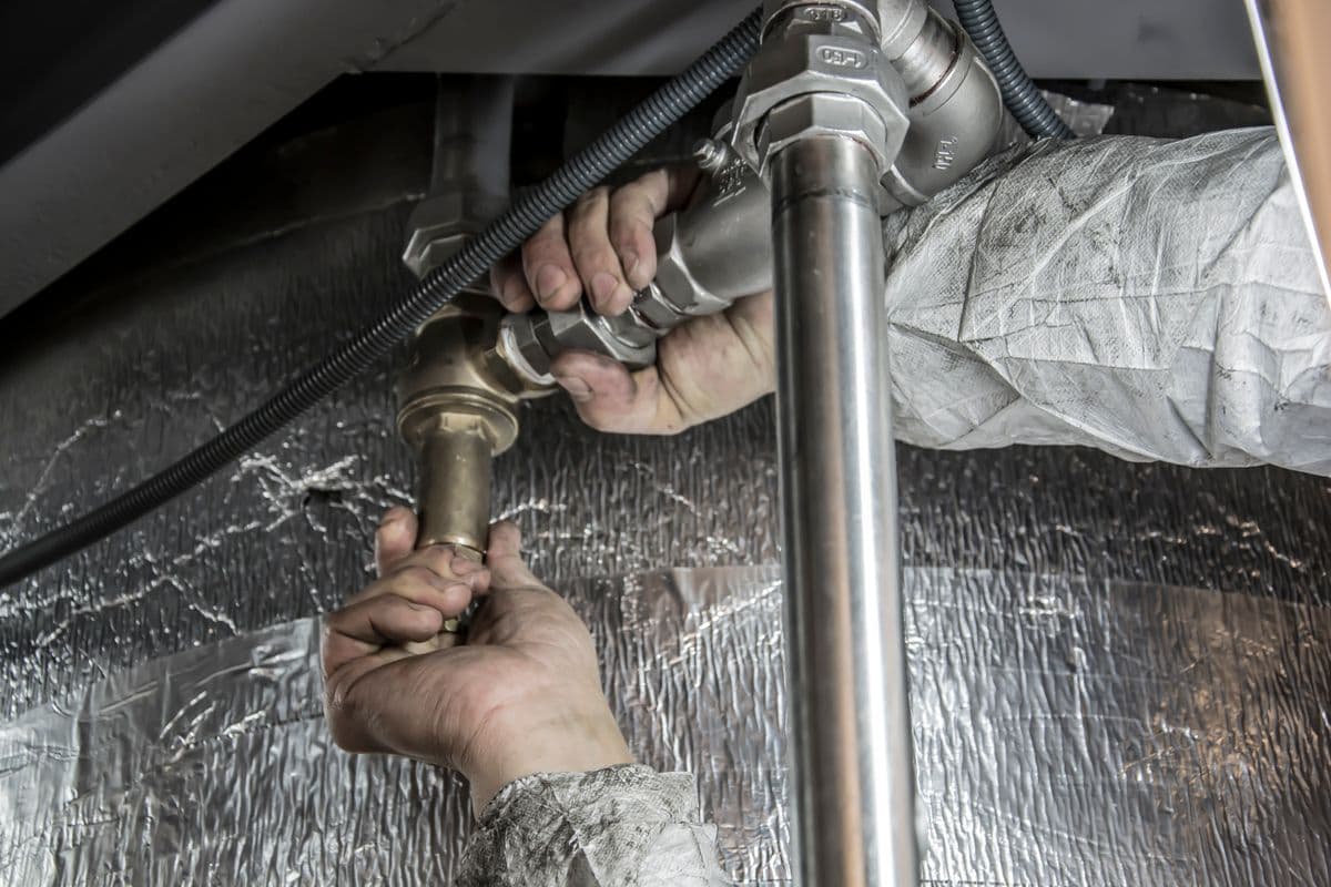 Fontanero instalando tuberías de acero en un interior