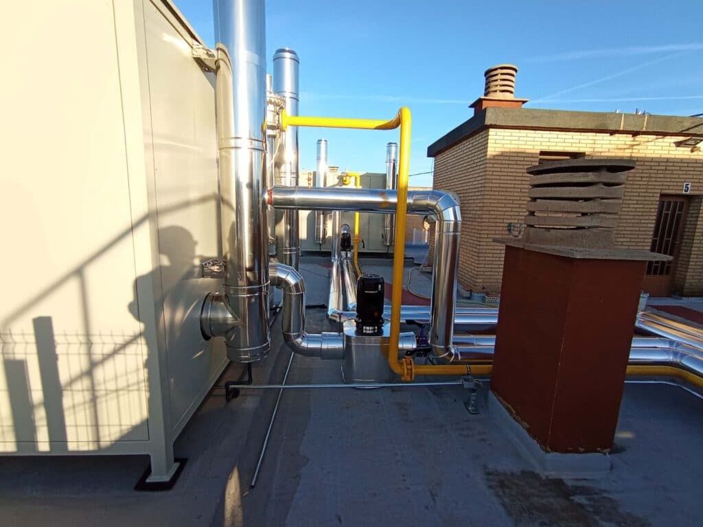 Instalación de gas en cubierta con tubería amarilla y chimeneas de acero inoxidable